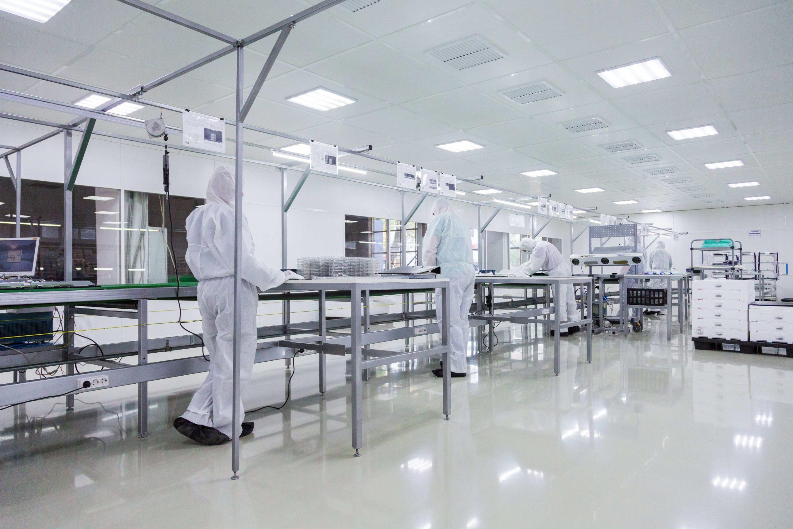 Workers working in a cleanroom environment, ensuring precision and contamination control.