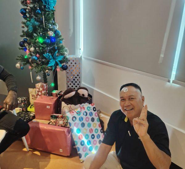 employee peace sign photo taking beside christmas tree